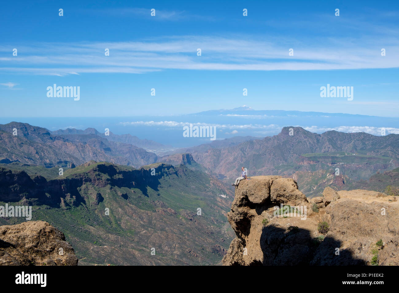 L'uomo guarda da Roque Nublo oltre il paese di montagna di Gran Canaria con il vulcano Teide All'orizzonte, Gran Canaria Isole Canarie Spagna Foto Stock