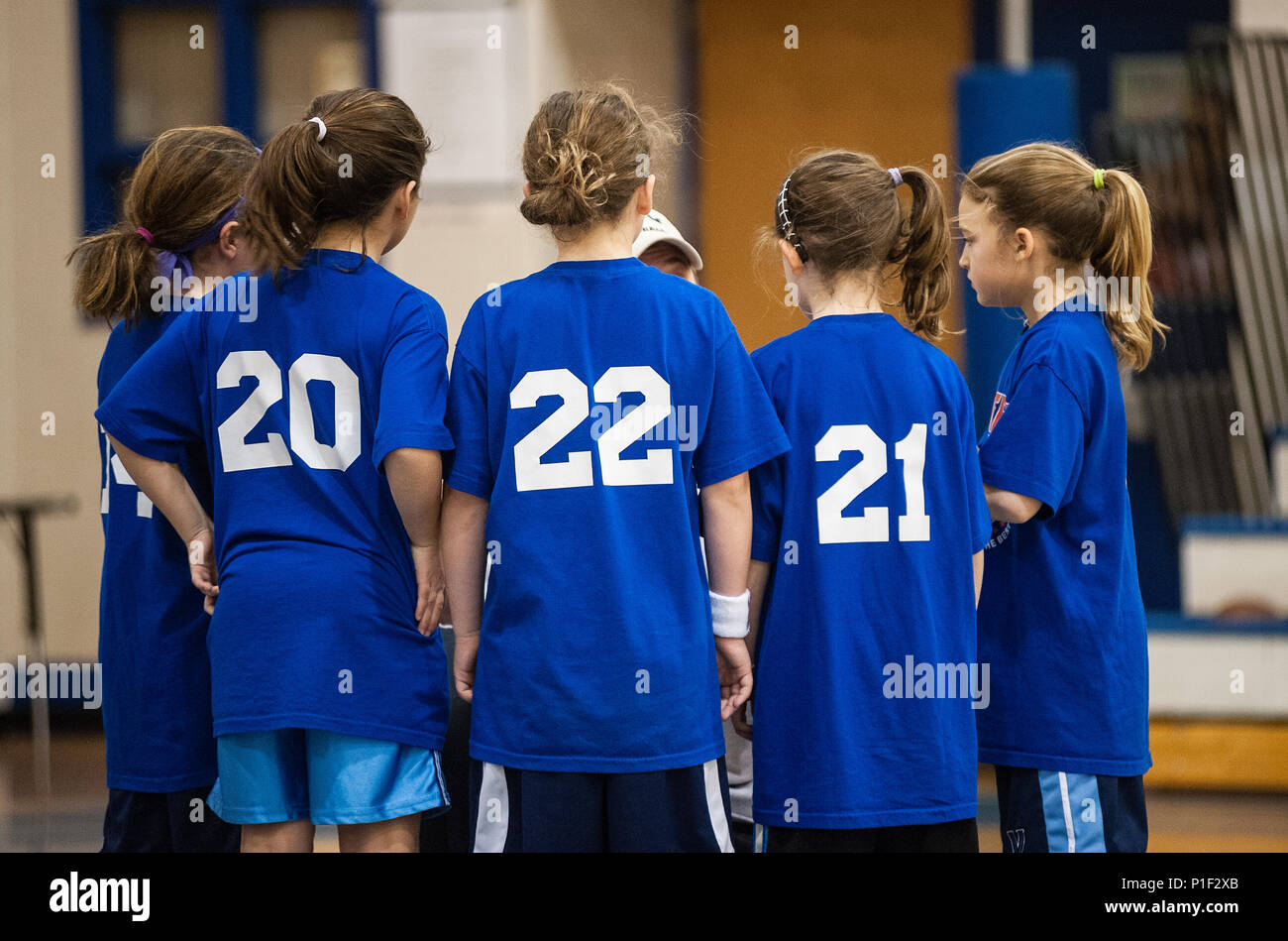 Le ragazze della gioventù coach di pallacanestro di istruire il suo team. Foto Stock