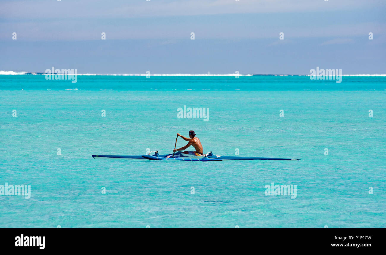 Il tahitiano canoisti godendo il loro mestiere nelle limpide acque blu dell'atollo. Foto Stock