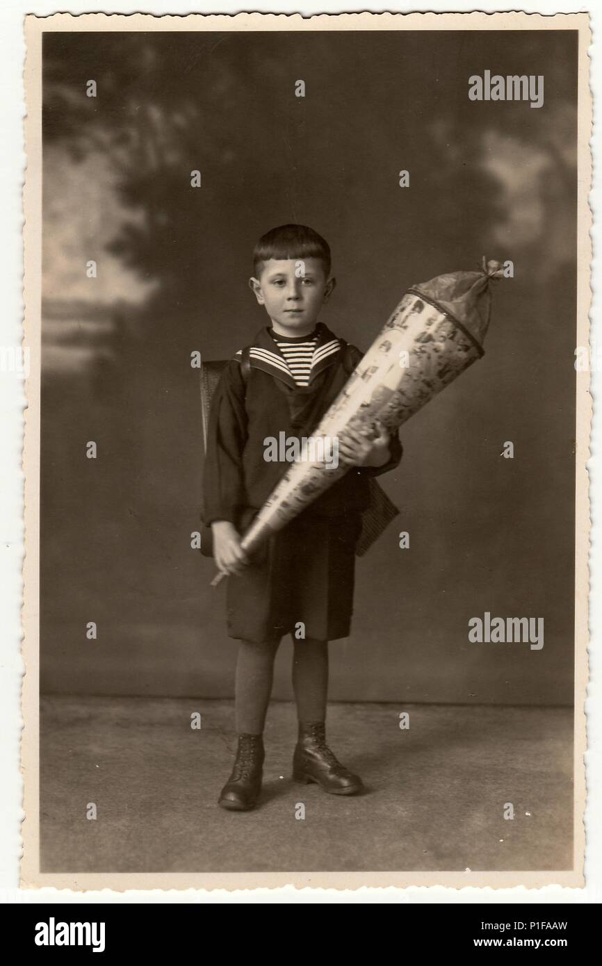 EILENBURG, GERMANIA - CIRCA 1920s: Foto d'epoca mostra il ragazzo con il cono della scuola. Foto studio con tinta seppia. 1920s Foto Stock