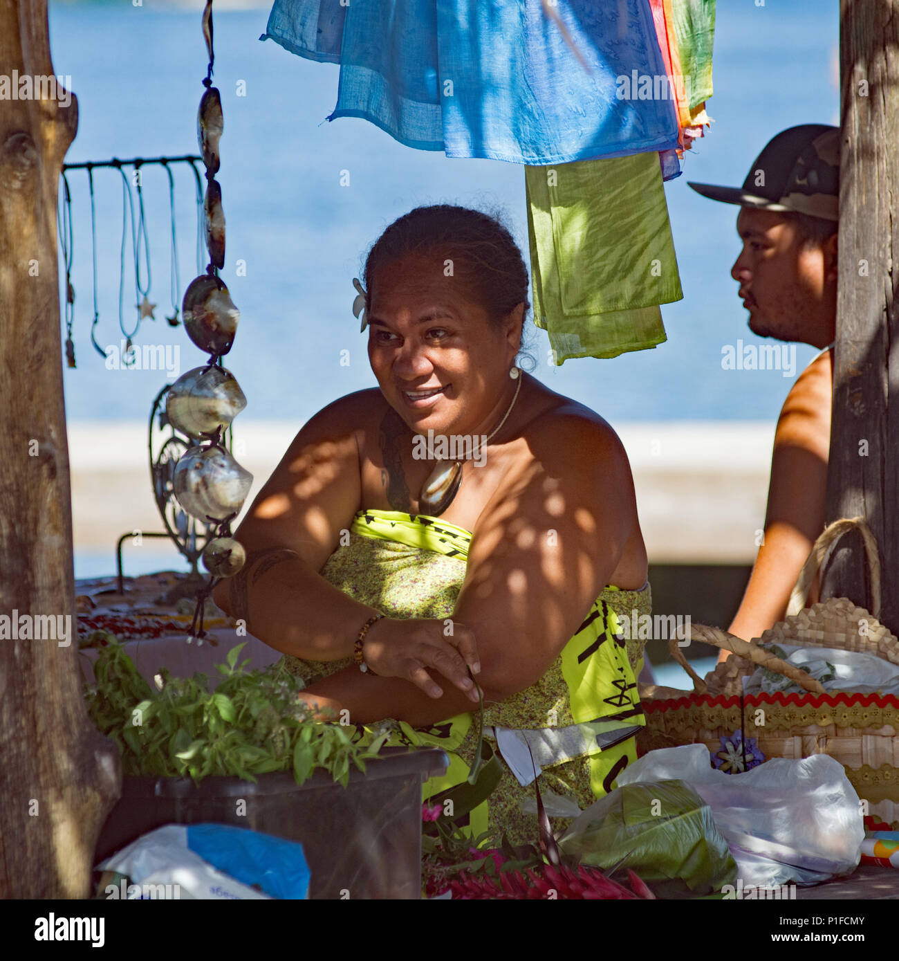 Donna polinesiana e giovane uomo seduto in mare sul mercato Paul Gauguin crociera a Huahine Island Foto Stock