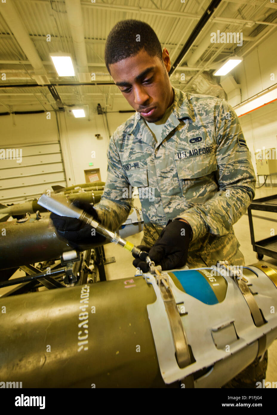 Airman 1. Classe Ginseler Saint-Vil, 5° Squadrone munizioni linea tecnico di consegna, stringe le viti su un GBU-38 naso aero-gruppo di superficie a Minot Air Force Base, N.D., Ottobre 27, 2016. Durante la costruzione della bomba, viti di fermo siano serrate per fissare il naso aero-gruppo di superficie di un inerte 500 lb. MK82 bomba. (U.S. Air Force foto/Airman 1. Classe J.T. Armstrong) Foto Stock