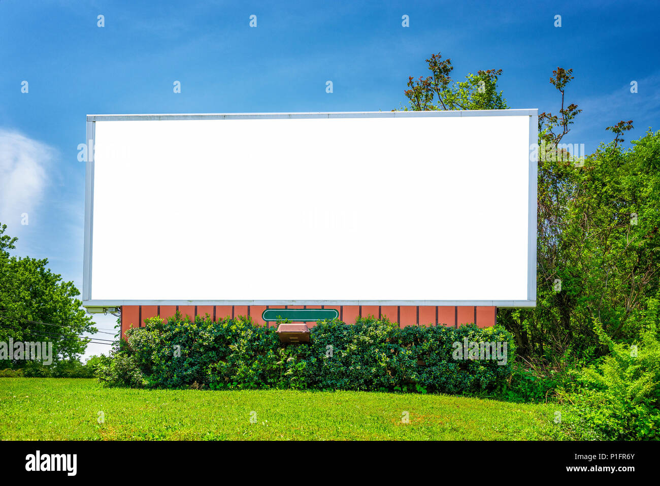 Inquadratura orizzontale di un fustellato neighorhood billboard sotto un cielo blu circondato dal verde. Foto Stock