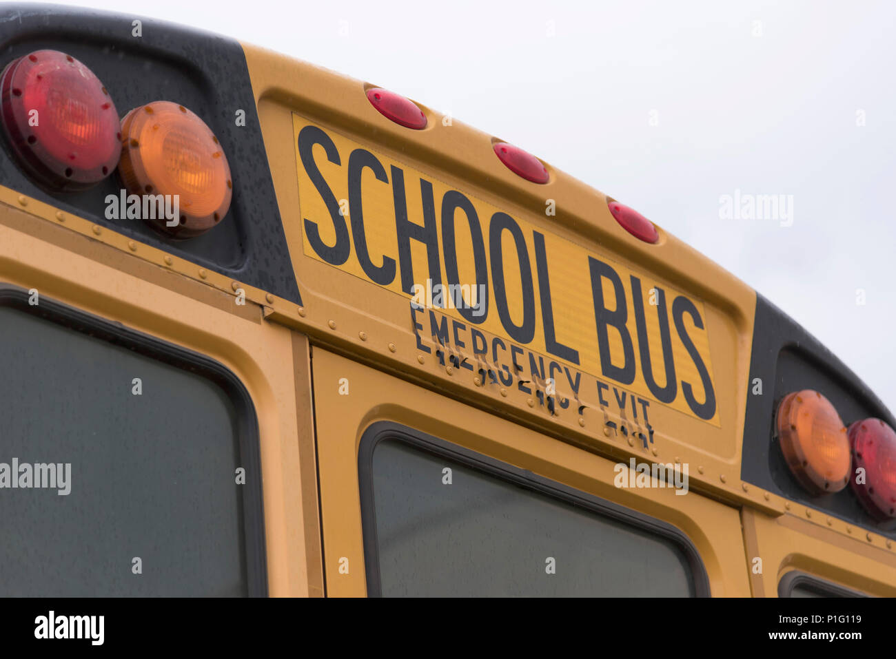 Bossier City, La., U.S.A - gen. 16, 2017: una scuola bus è parcheggiata in un cortile della scuola. Un primo piano mostra i lampeggiatori posteriori e le parole, 'scuola bus.' Foto Stock