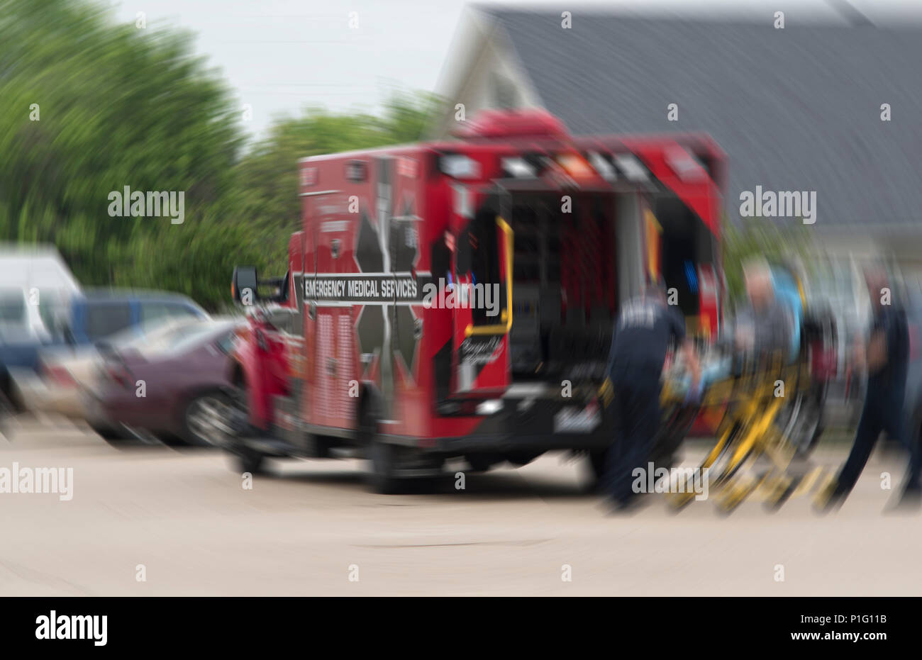 Solo le parole 'il servizio di emergenza medica' sull'ambulanza sono leggibili, come EMTs preparare per mettere il paziente in una ambulanza. Nessuno è riconoscibile Foto Stock