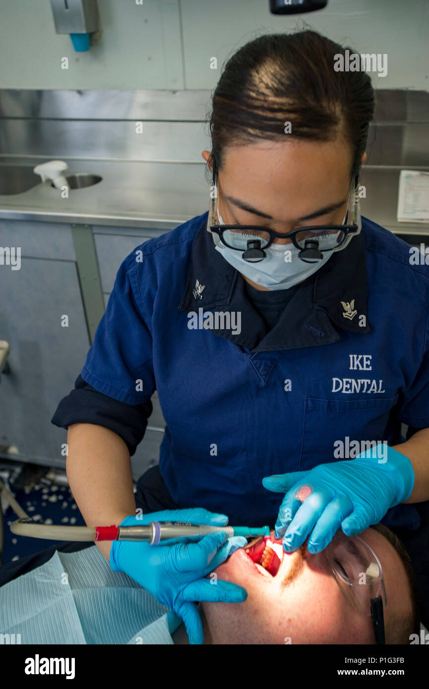 161031-N-WS581-036 GOLFO ARABICO (ott. 31, 2016) Petty Officer Secondo Corry Reyes, top da Murrieta, California, esegue una pulizia dentale su Sottufficiali di terza classe David Ryan nel dentale baia della portaerei USS Dwight D. Eisenhower CVN (69) (IKE). Reyes serve a bordo di IKE come un ospedale corpsman ed è responsabile per la pulizia dentale, attrezzature di manutenzione e di igiene dentale formazione. Ike e la sua portante Strike gruppo vengono distribuiti a supporto di funzionamento inerenti risolvere, le operazioni di sicurezza marittima e di teatro la cooperazione in materia di sicurezza gli sforzi negli Stati Uniti Quinta Flotta area di operazioni. (U.S. Foto Stock