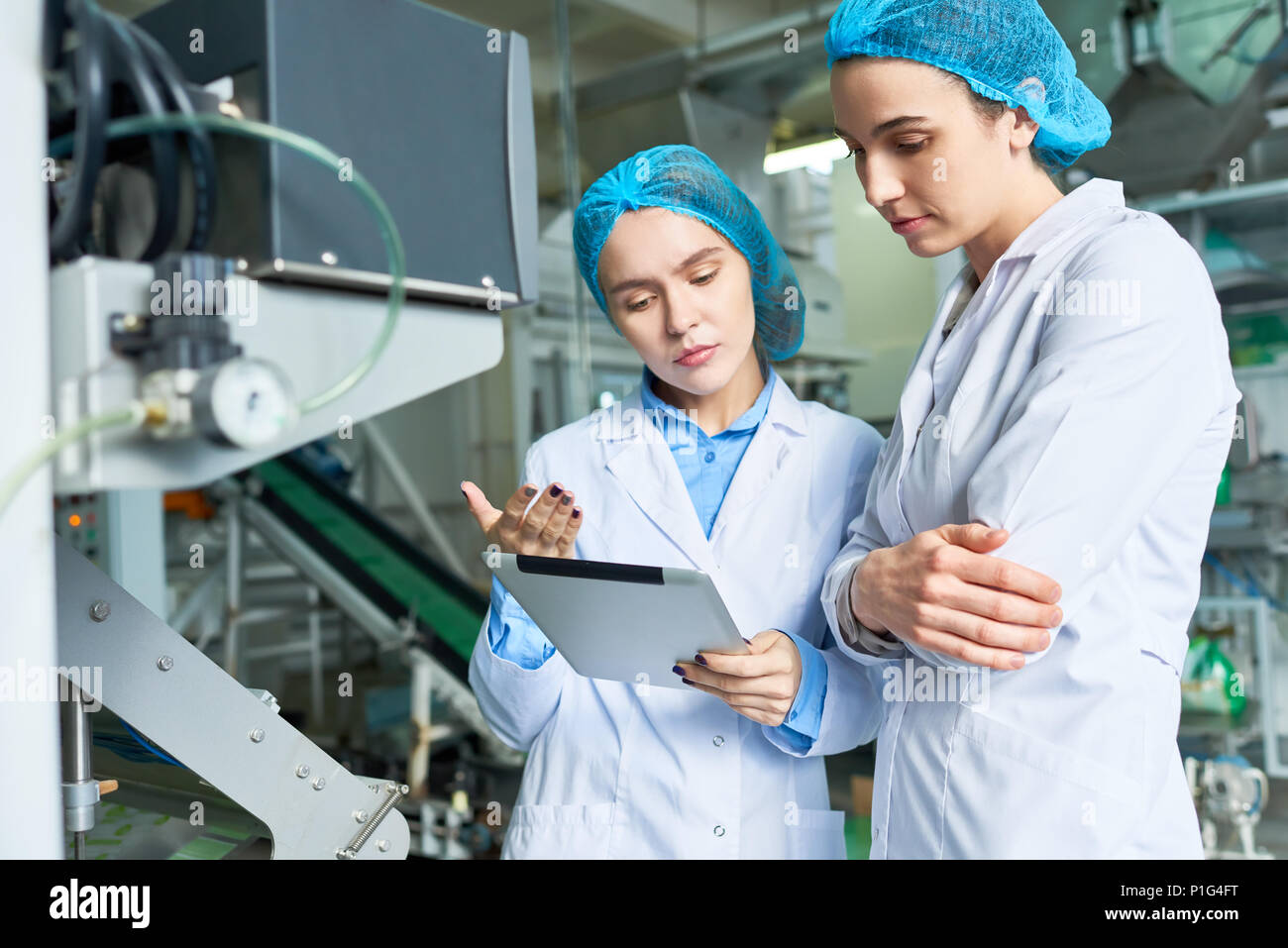 Due dei lavoratori di sesso femminile in fabbrica Foto Stock