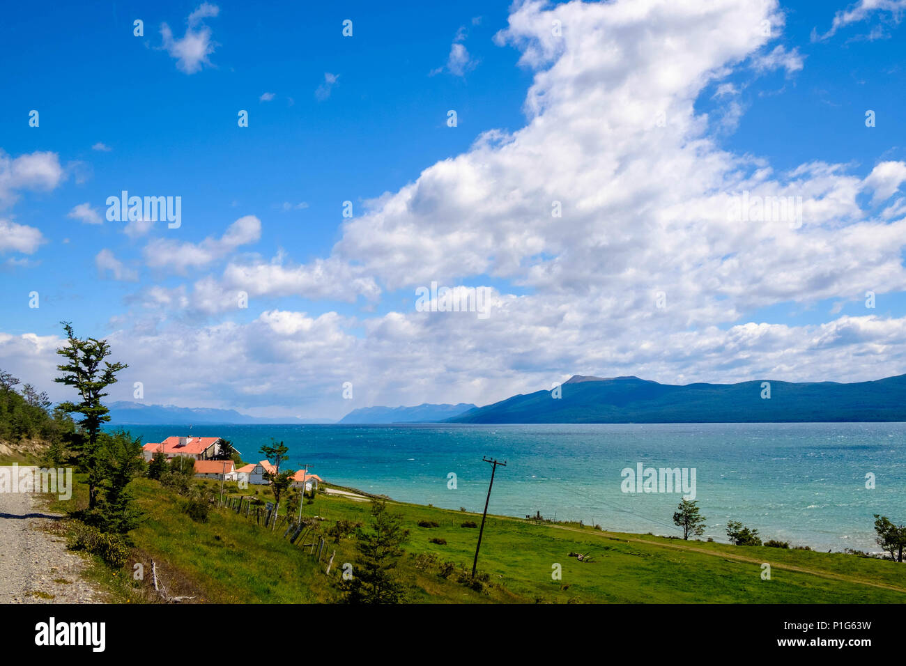 I colori mozzafiato del Lago Cami sono rinforzati dal sole. Alcune case isolate offrono una vista brillante sui dintorni. Foto Stock