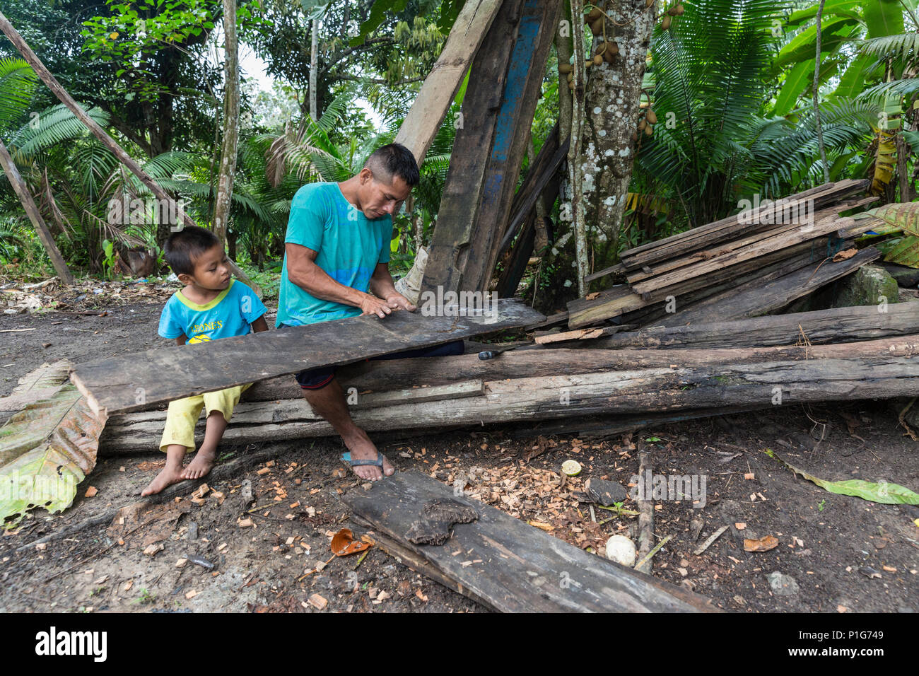 L'uomo utilizzando machete per lavorare legno, San Francisco Village, Loreto, Perù Foto Stock