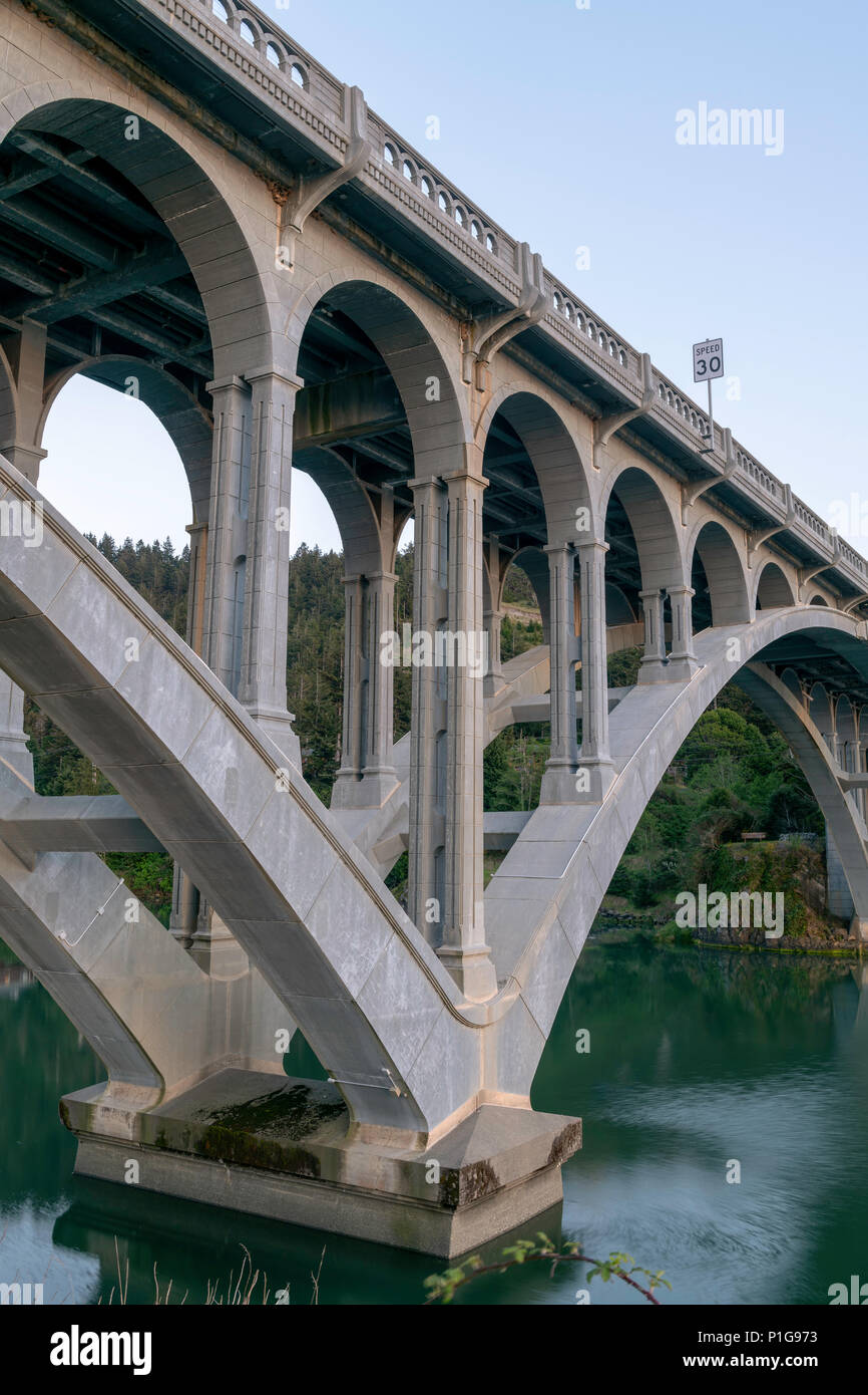 Palificazioni e gli archi della Rogue River Bridge in oro Beach, Oregon al tramonto Foto Stock