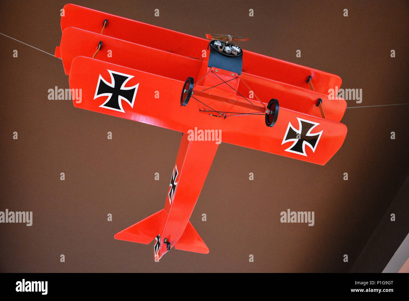 Modello di colore rosso del piano tedesco dalla prima guerra mondiale, chiamato anche grande guerra. Piano di modello con doppie ali e due croci di ferro. Modello di aeroplano double alato. Foto Stock