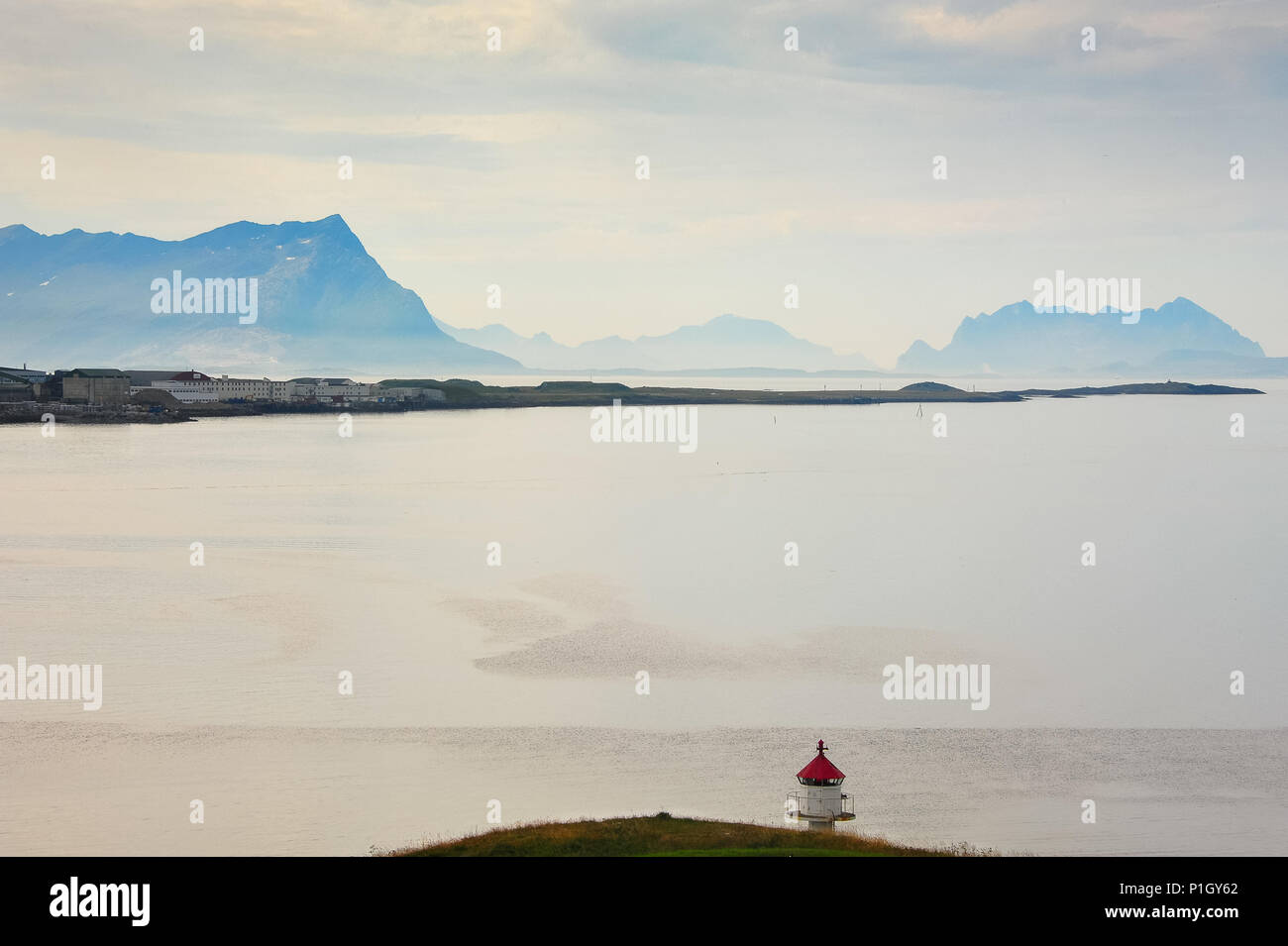 Il pittoresco paesaggio norvegese - Nyholmen faro, montagne in lontananza e una calma, mare vetroso Foto Stock