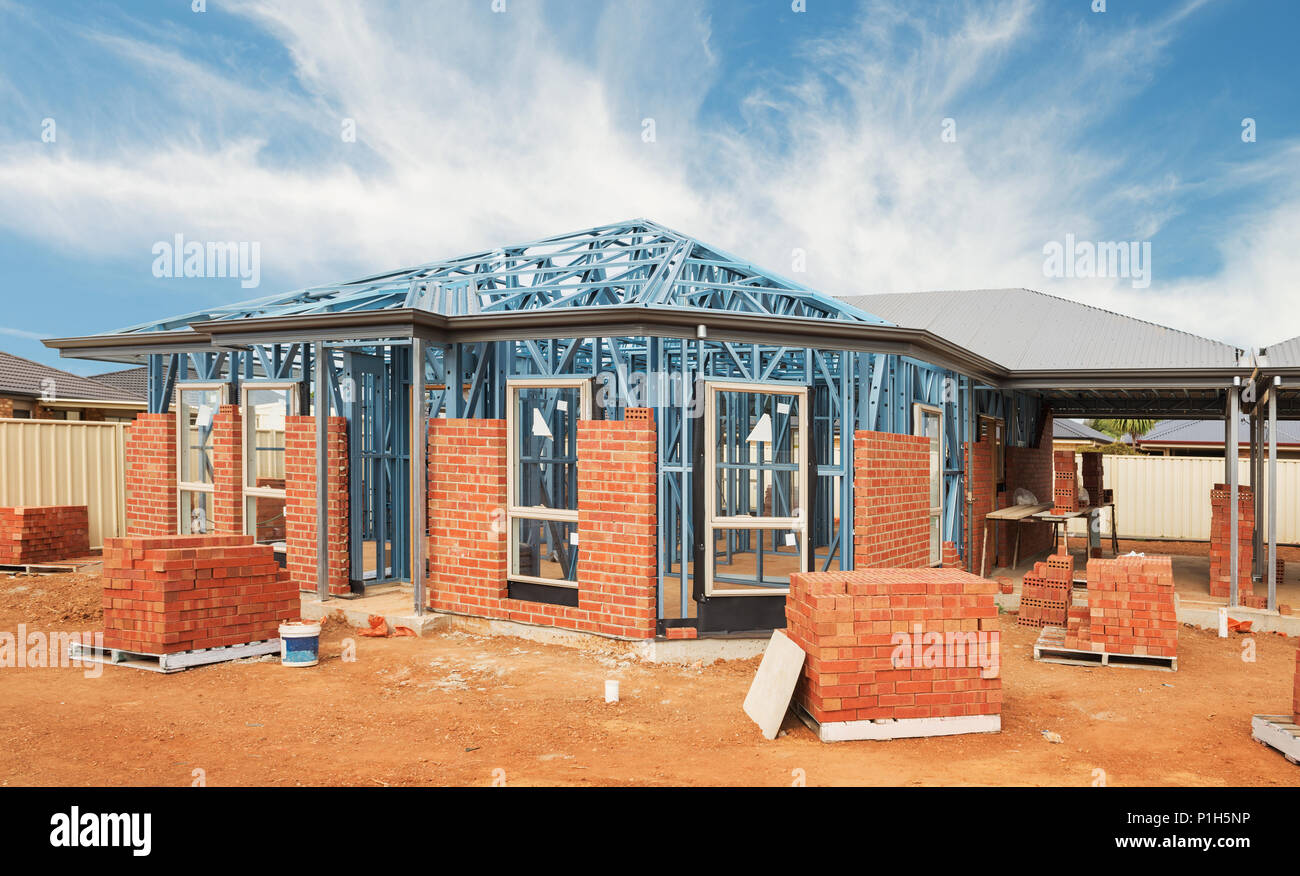Nuove costruzioni residenziali casa in mattoni con telai metallici contro un cielo blu Foto Stock