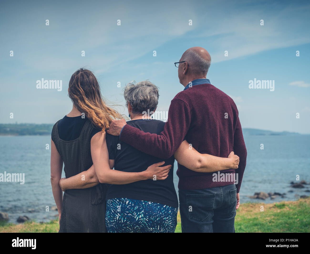 Una coppia senior con la loro figlia adulta sono in piedi vicino al mare Foto Stock