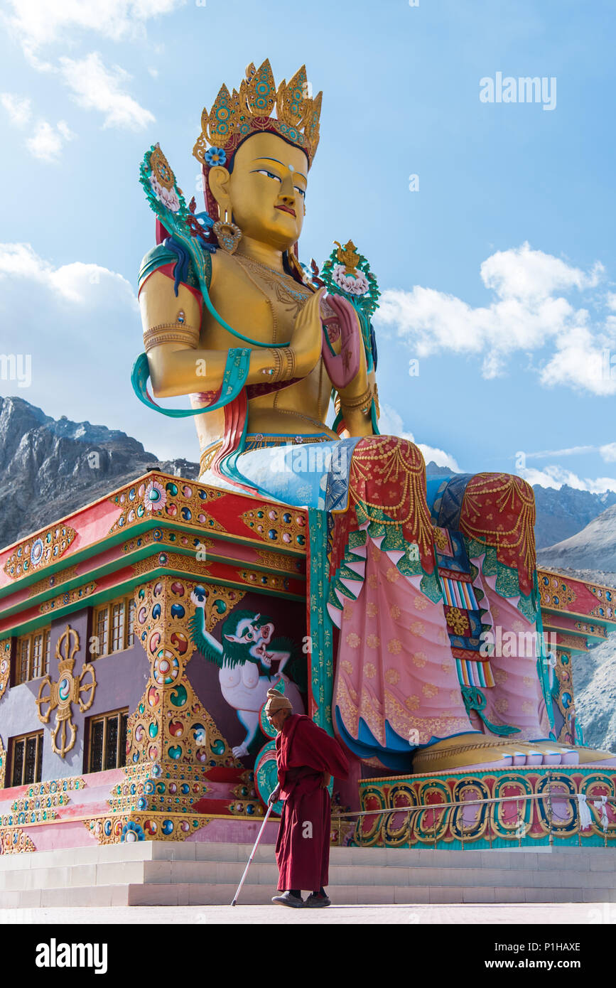 Big Buddha Maitreya statua con lama buddista pregare a piedi a Diskit Monastero, Nubra valley. Leh Ladakh, India. Foto Stock