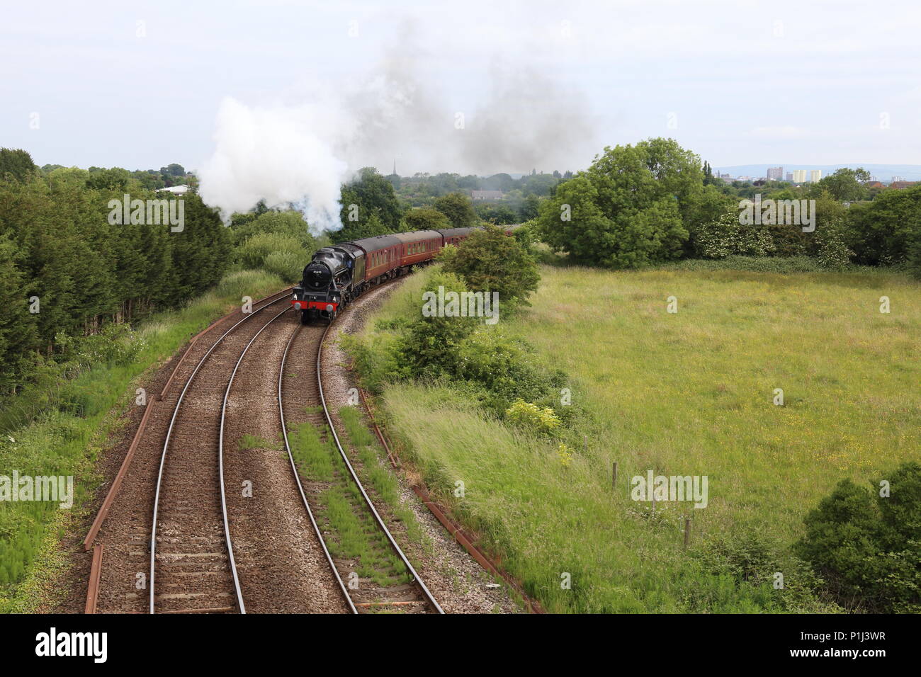 Il Fellsman locomotiva a vapore conduce i suoi carrelli attorno alla curva Farington sul suo viaggio fino il Settle Carlisle trogolo ferroviaria Lancashire campagna. Foto Stock