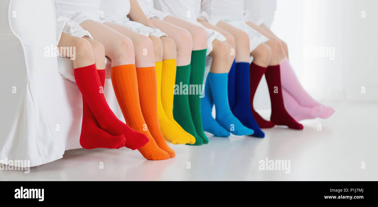 I bambini che indossano colorati calzini arcobaleno. Calzature per bambini  raccolta. Varietà di maglia alta del ginocchio calze e collant. Bambino  Abbigliamento e capi di vestiario. Kid fash Foto stock - Alamy