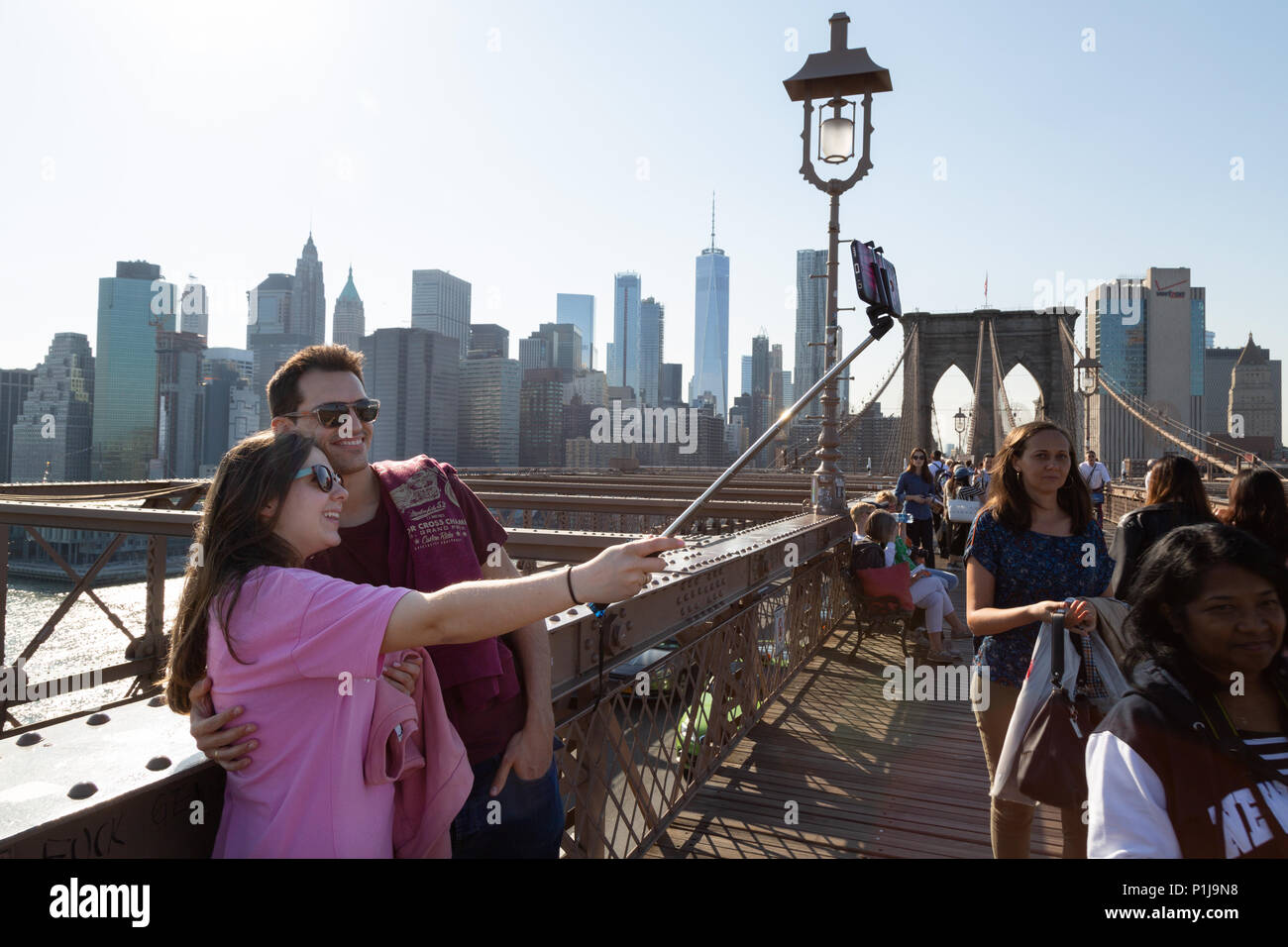 Giovane prendendo un selfie, Ponte di Brooklyn, Manhattan, New York City USA Foto Stock