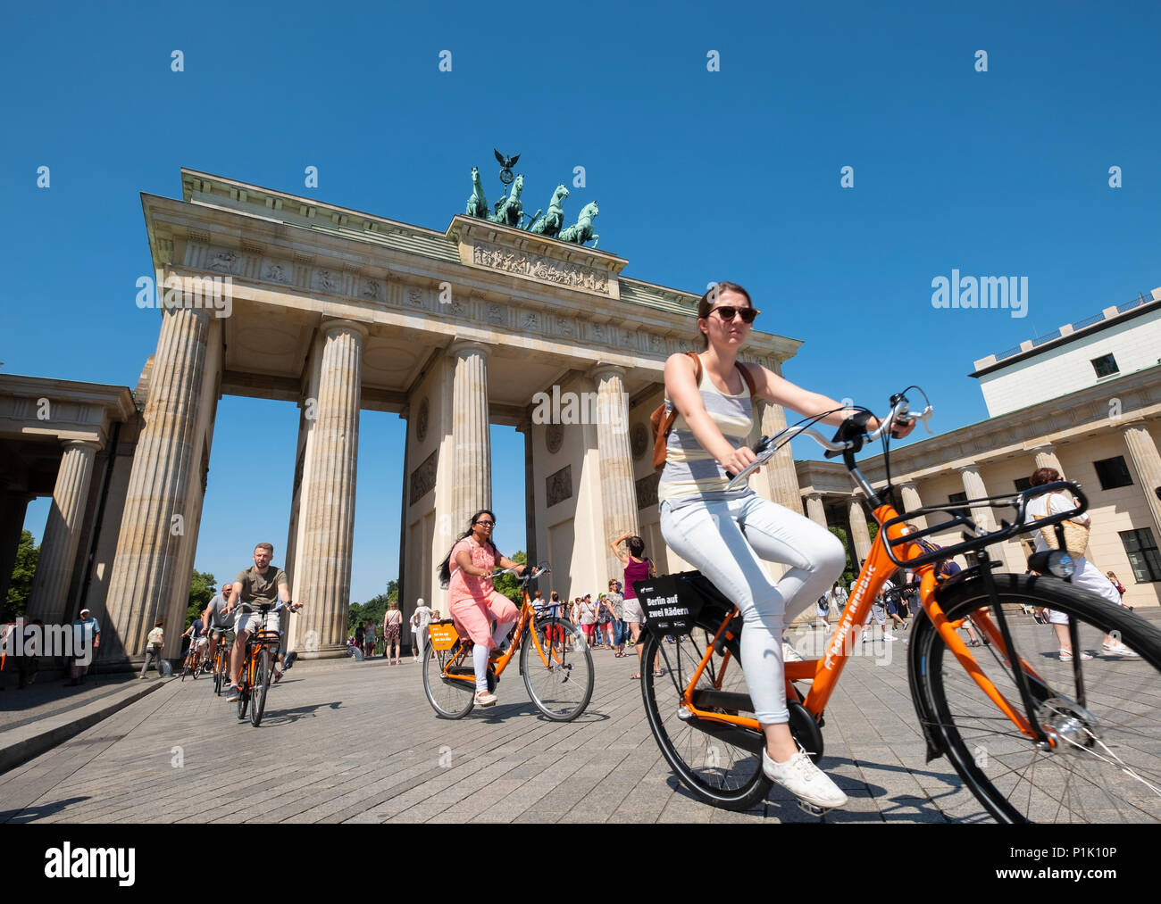 I turisti in bicicletta nella parte anteriore della porta di Brandeburgo a Berlino, Germania Foto Stock