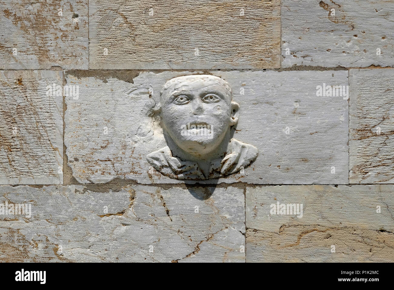 Grottesco volto scolpito sul muro di pietra, Pisa, Toscana, Italia Foto Stock