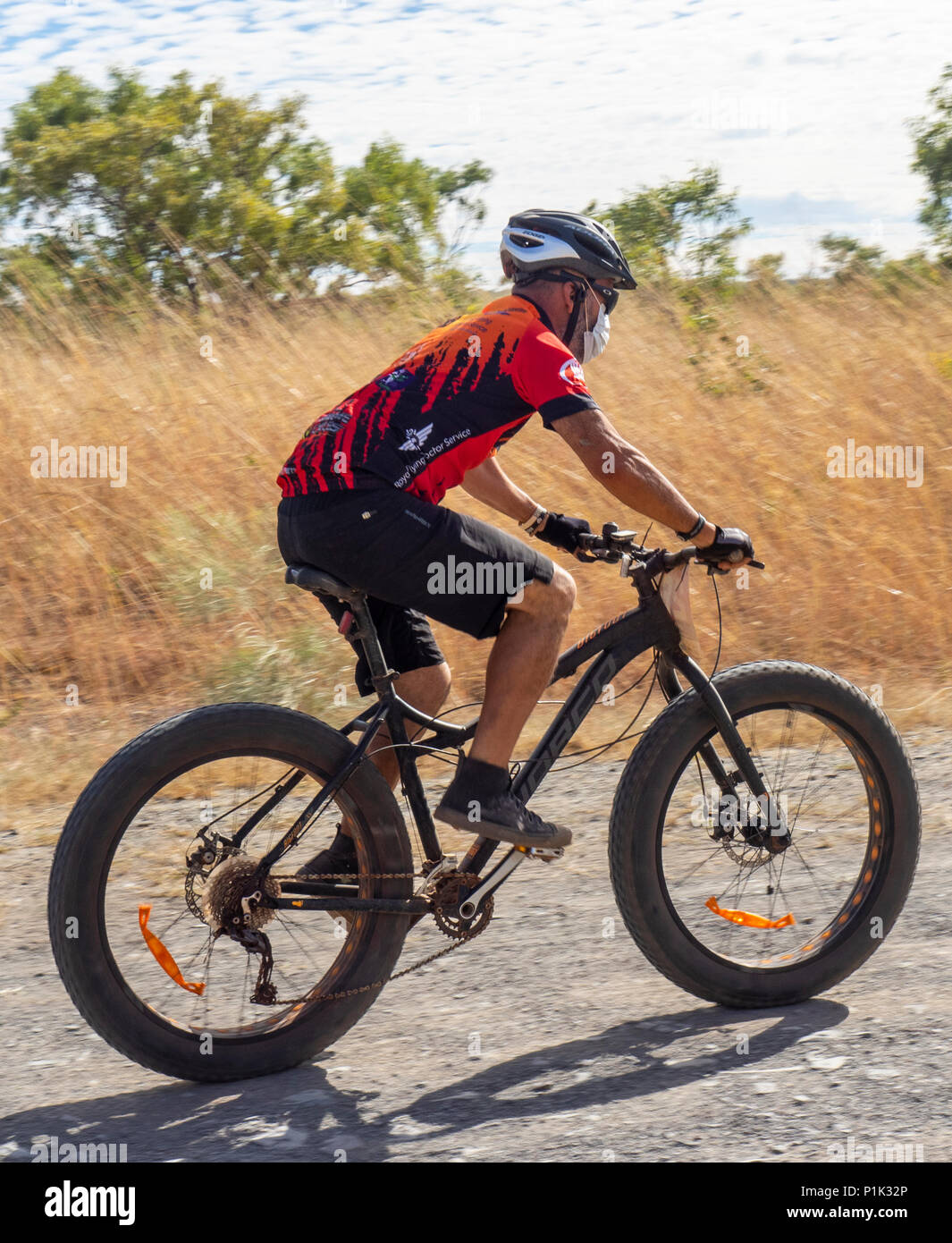 Gibb Challenge 2018 un maschio ciclista in jersey e bib a cavallo di un fatbike su strada sterrata Gibb River Road WA Kimberley Australia. Foto Stock