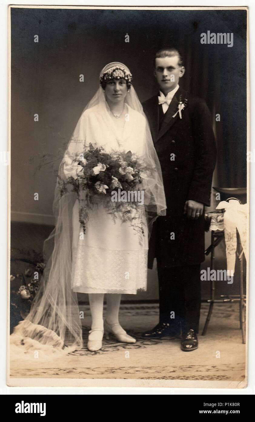 CHRASTAVA (KRATZAU), LA REPUBBLICA CECOSLOVACCA - CIRCA 1930s: Foto d'epoca  degli sposi novelli. La sposa indossa un lungo velo e contiene bouquet di  nozze. Lo sposo indossa un abito nero e un