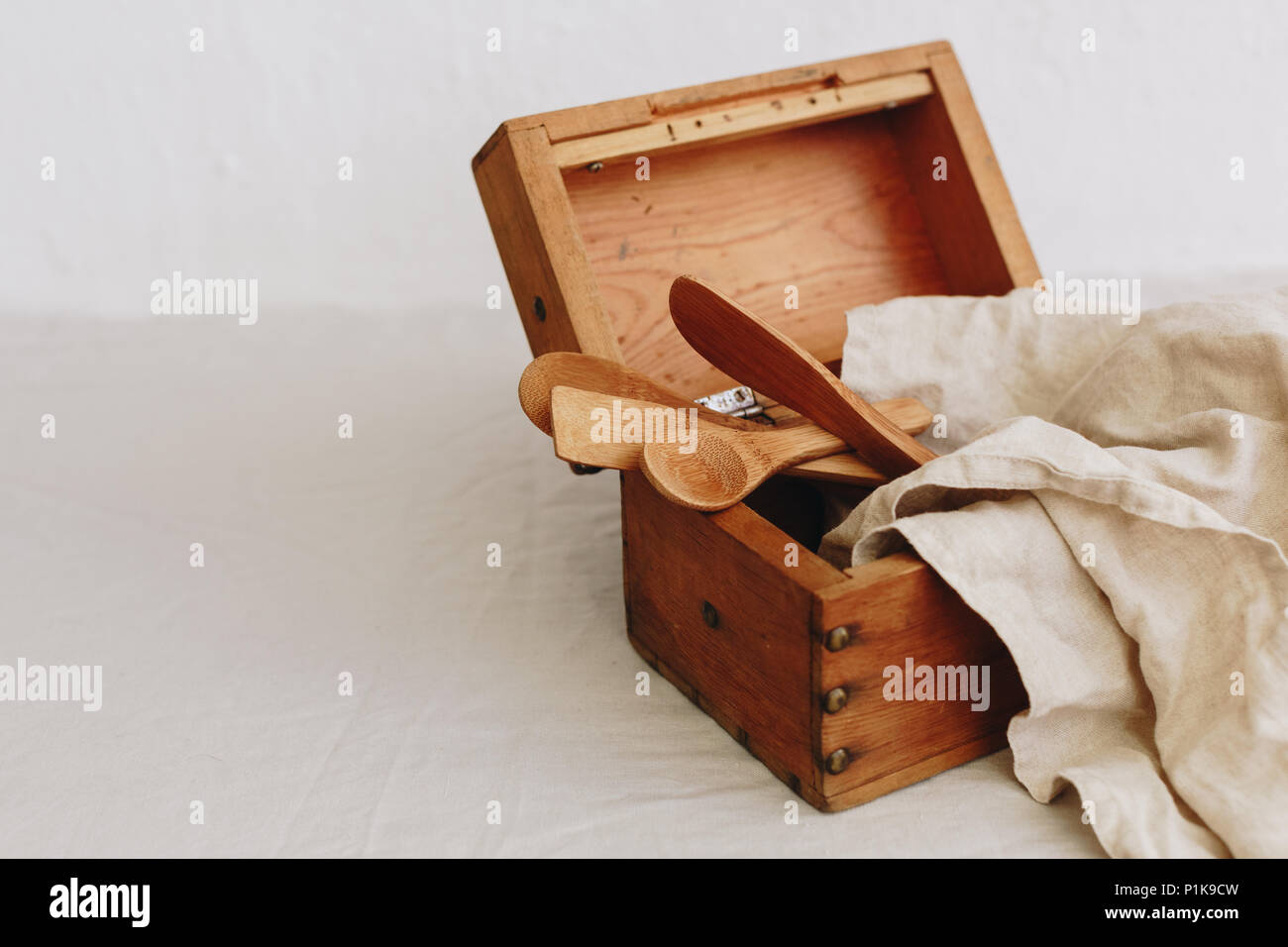 Scatola di legno con utensili da cucina e un tovagliolo di lino Foto Stock