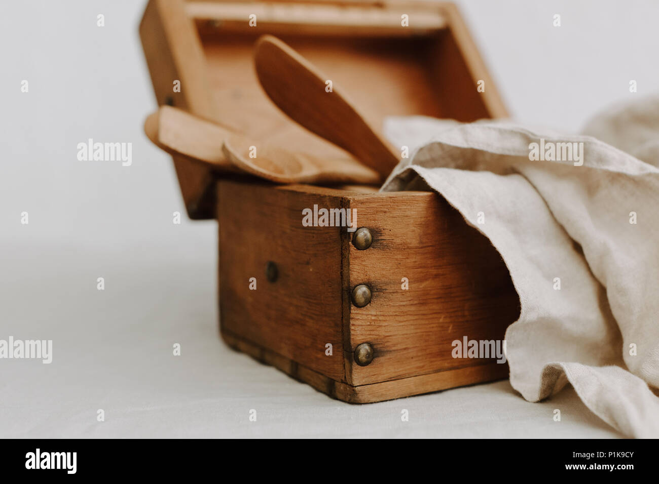 Scatola di legno con utensili da cucina e un tovagliolo di lino Foto Stock