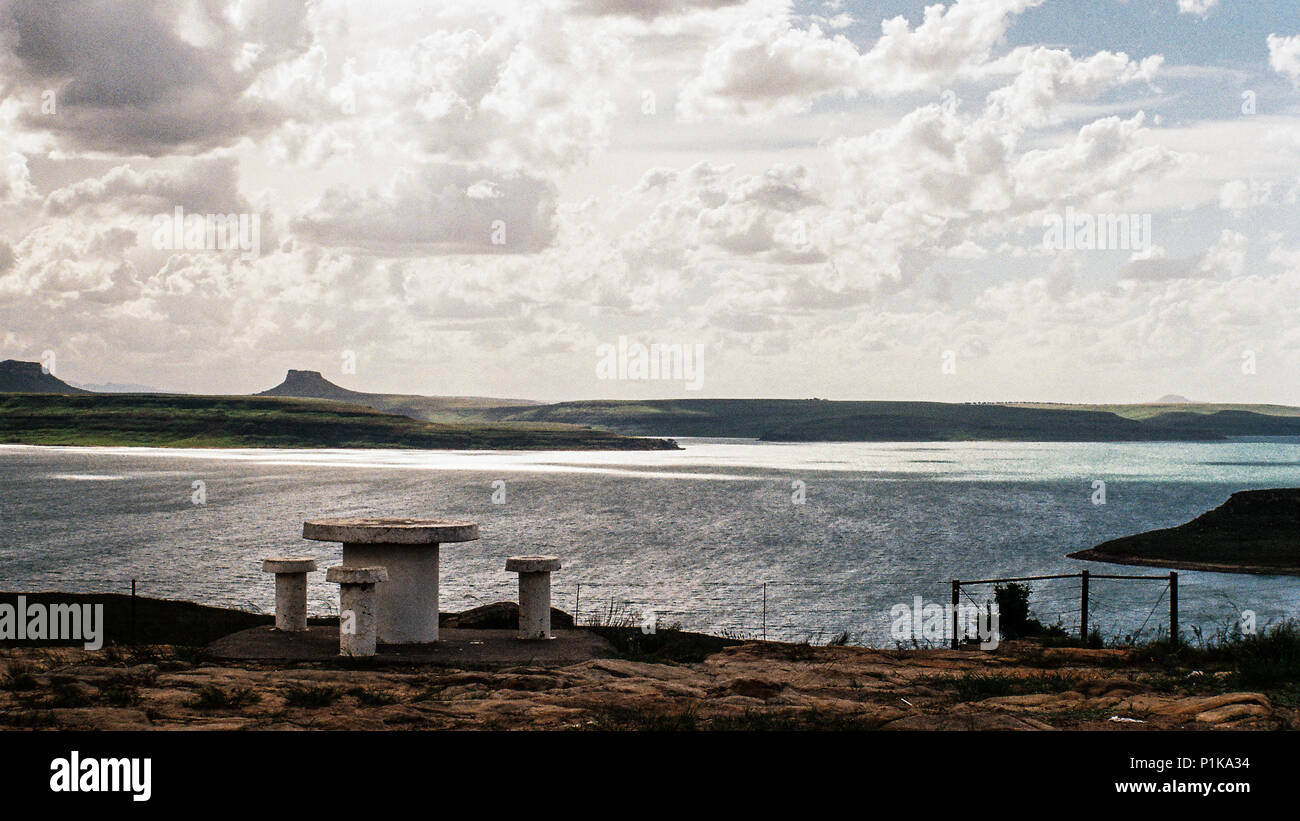 Banco di cemento e le tabelle da un lago, Sud Africa Foto Stock