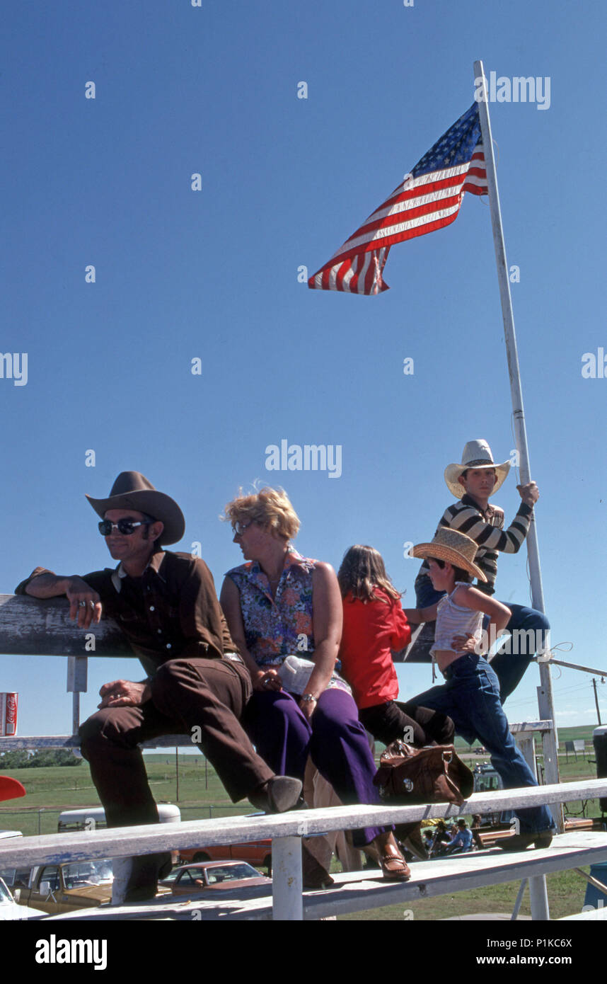 La famiglia a un rodeo stampede evento in Stapleton Nebraska con figlio tenendo in mano una bandiera americana Foto Stock