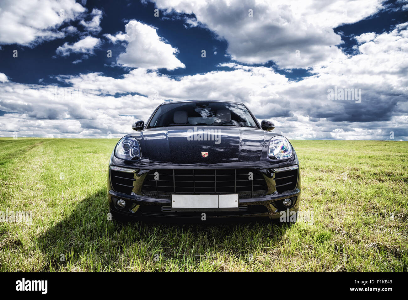 Porsche Macan è parcheggiato su un fresco verde erba di primavera Foto Stock