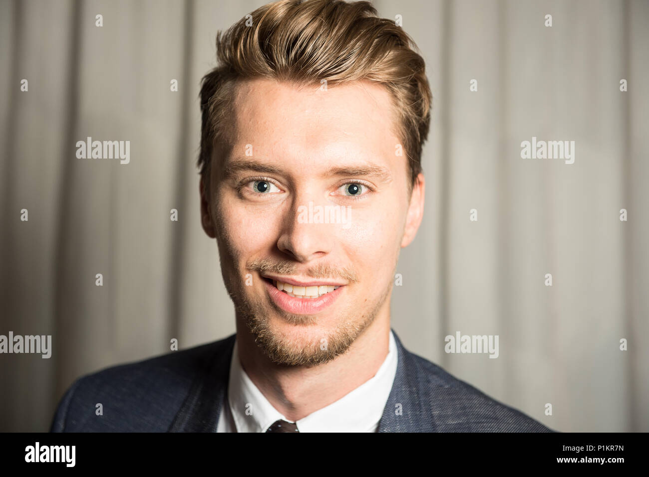 Ritratto di giovane uomo con gli occhi blu e capelli biondi Foto Stock