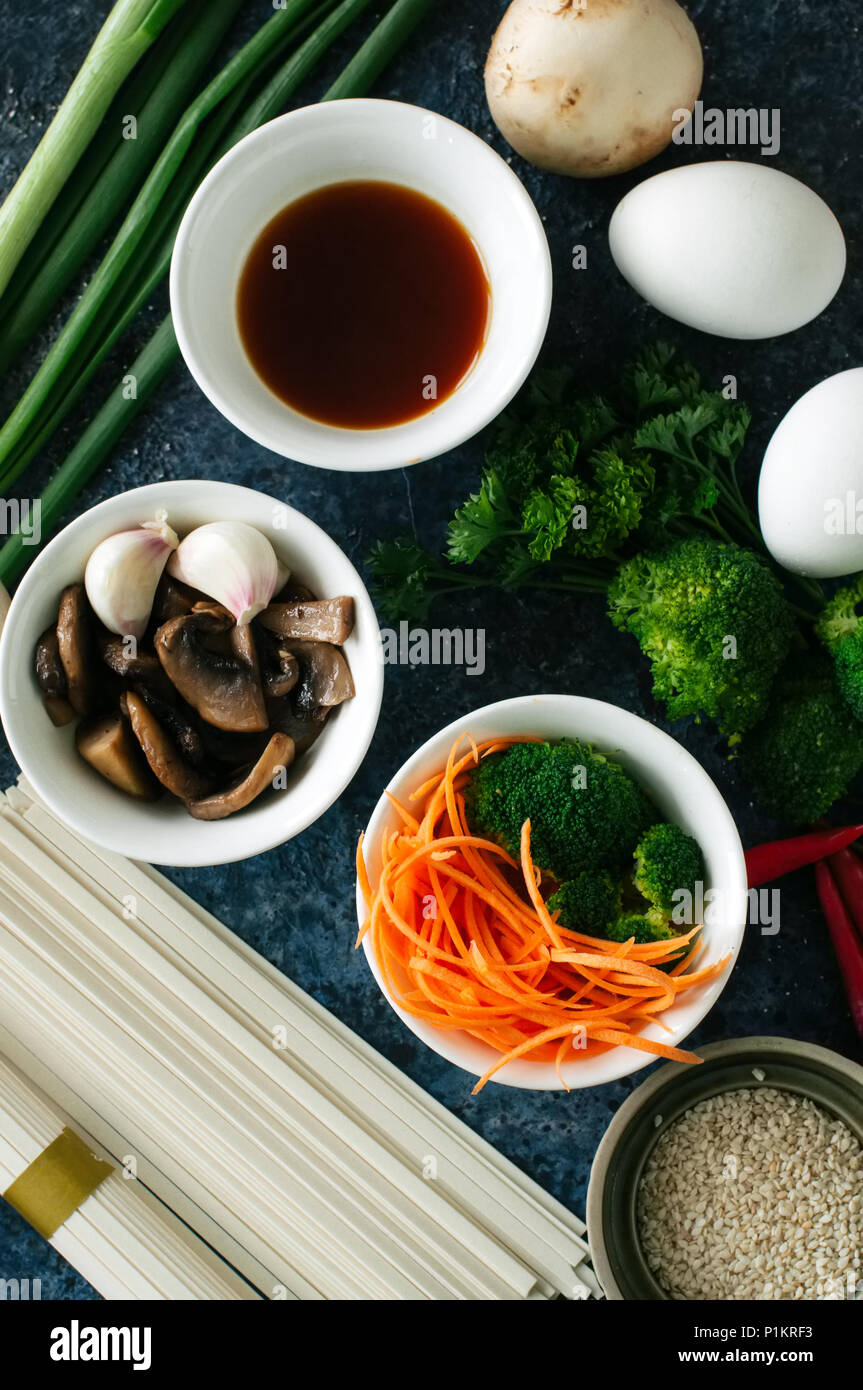 Ingredienti della cucina asiatica tagliatelle uova verdure salsa di spezie erbe. Appartamento laici vista superiore Foto Stock