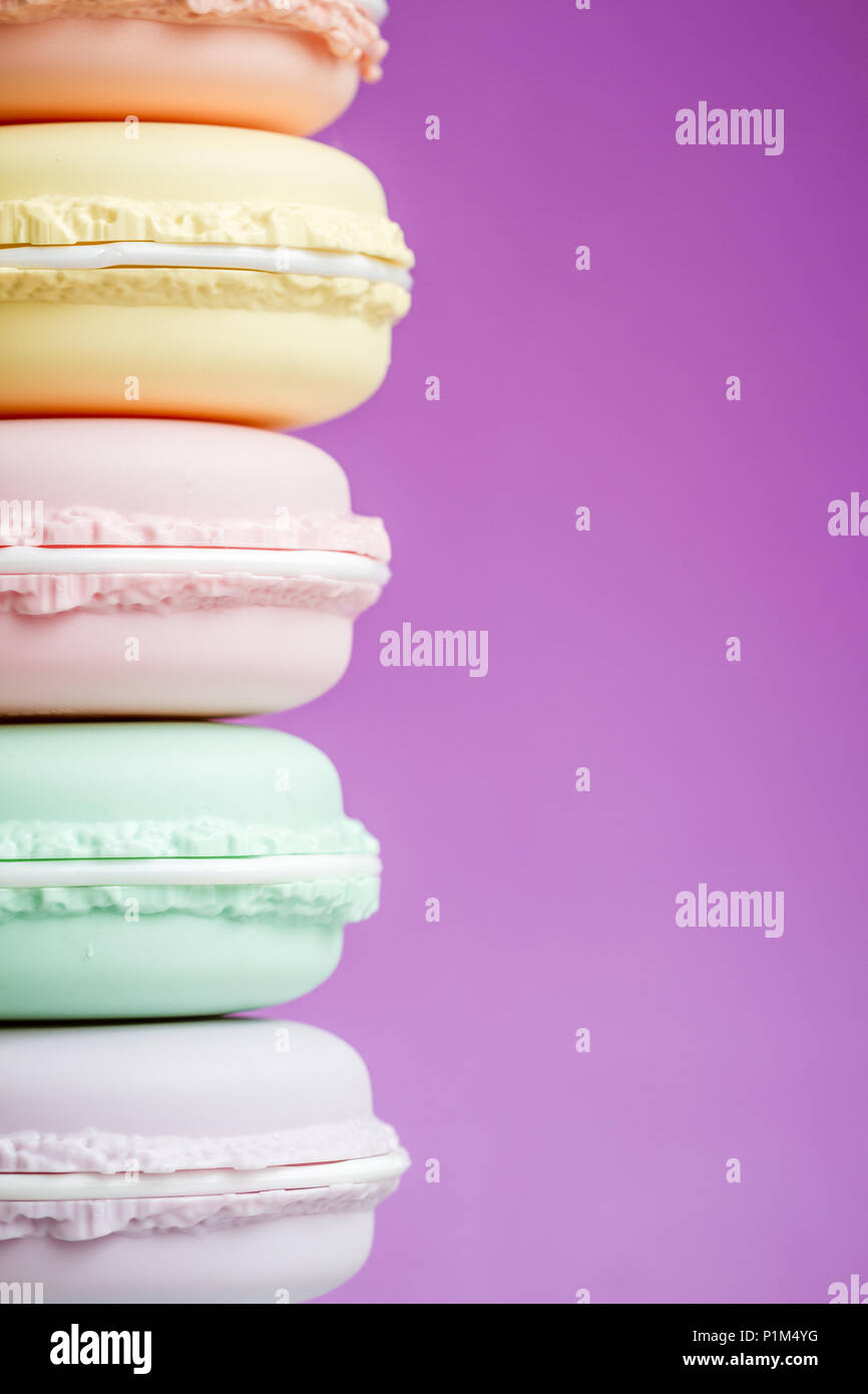 Colorate scatole di stoccaggio progettato come macarons su sfondo viola Foto Stock