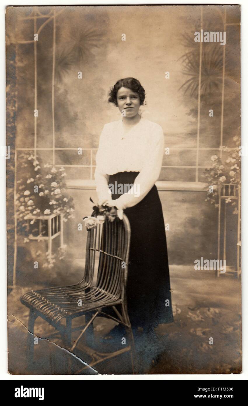 Germania - circa trenta: Vintage mostra fotografica di giovane donna pone con fiori in una foto in studio. La fotografia con effetto seppia. Foto Stock