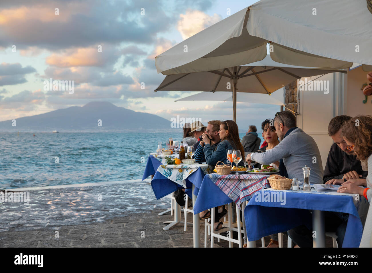 Porta a Marina ristorante nel porto di Marina Grande con il Vesuvio attraverso la baia di Napoli al tramonto, Sorrento, la Costiera Amalfitana, Campania, Italia Foto Stock