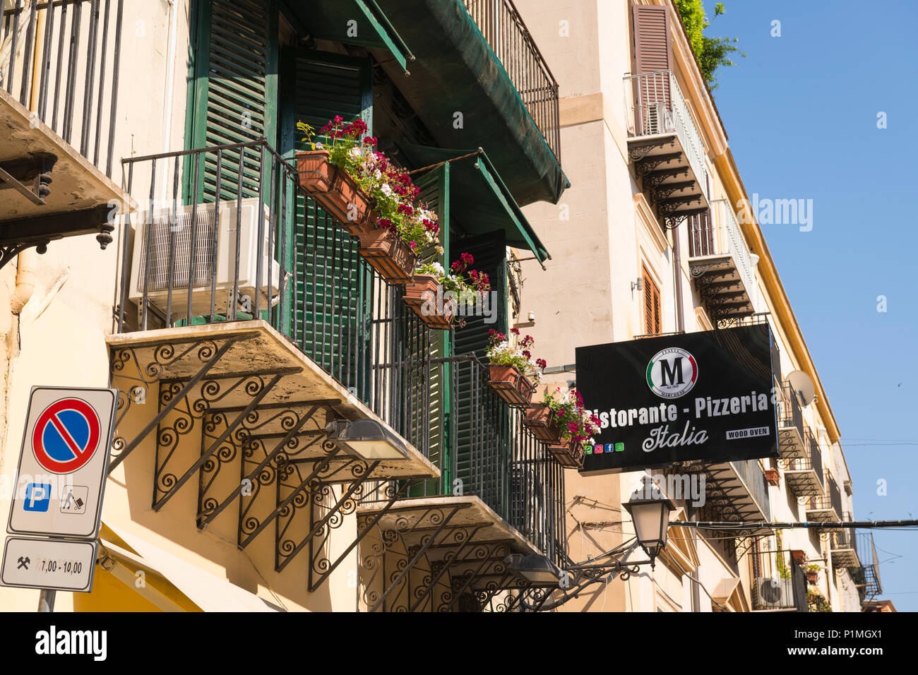 Italia Sicilia Palermo strada tipica scena di vecchi edifici balconi  serrande impianto fioriera scatole segno Ristorante Pizzeria forno a legna  Italia cielo blu Foto stock - Alamy
