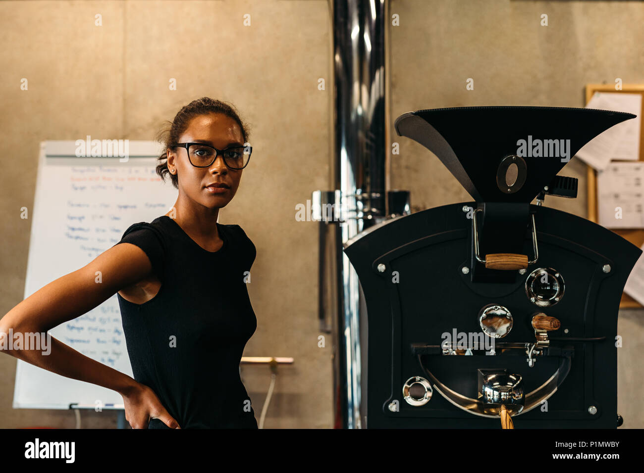 Ritratto di un giovane imprenditore nel suo caffè roastery Foto Stock