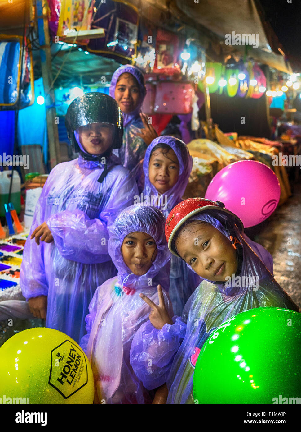 Un cambogiano umido famiglia lavoro-it per la telecamera nonostante la pioggia pesante Foto Stock