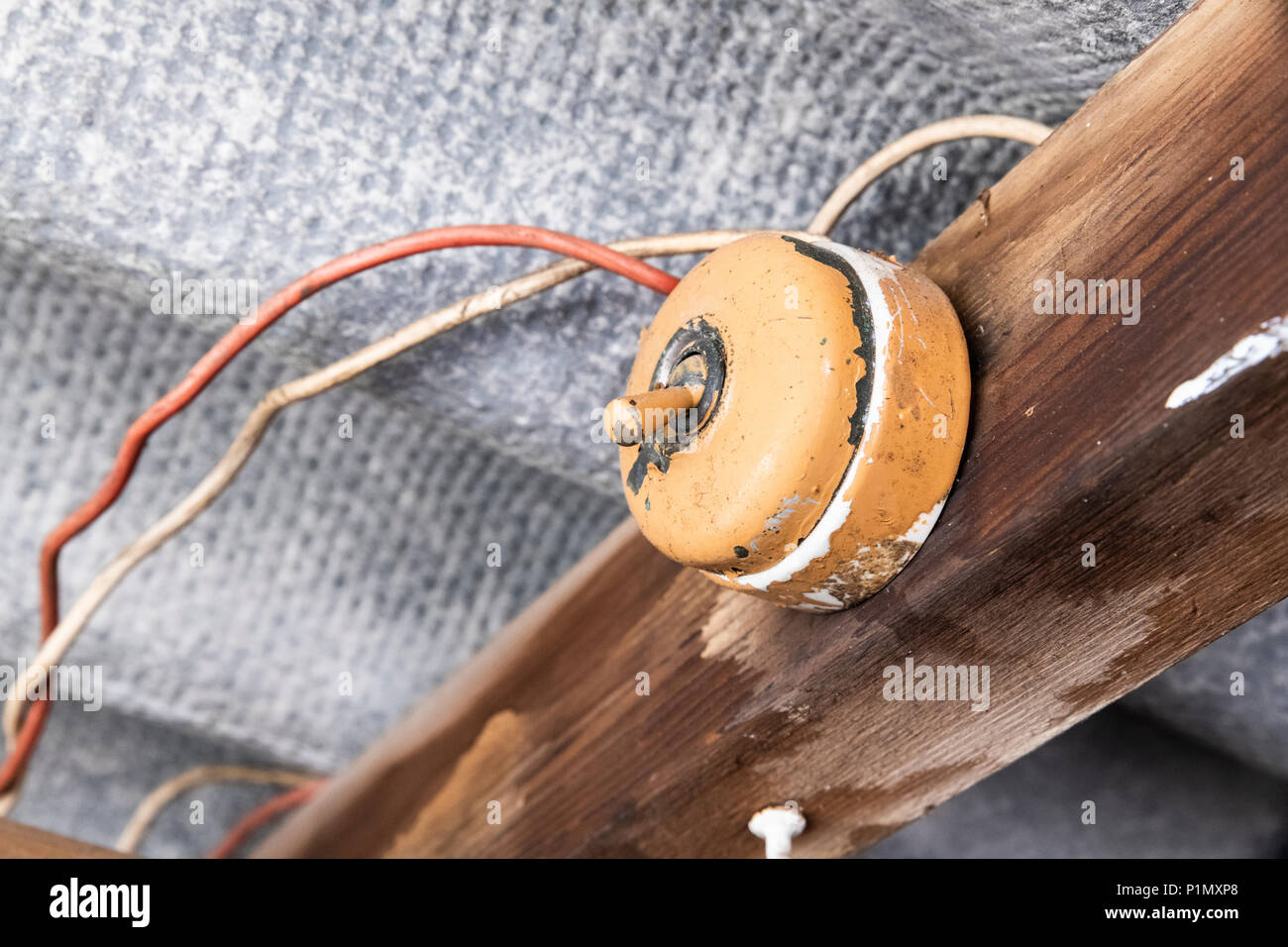 Il vecchio interruttore luce all'interno di un capannone con pericolose e cablaggio tetto in amianto Foto Stock