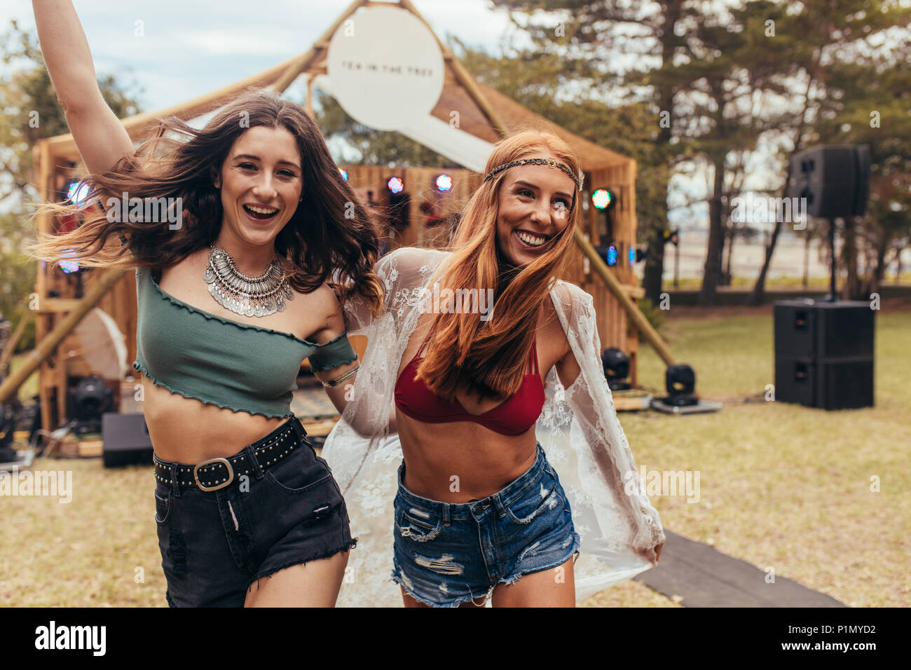 Raffreddare due ragazze stanno avendo divertimento presso il festival di musica al parco. Le donne amici in estate godendo di usura presso il festival di musica. Foto Stock