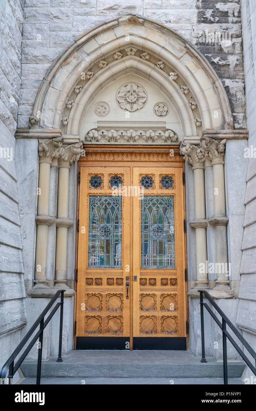 Stone arco gotico chiesa ingresso con porta a vetri colorati Foto Stock