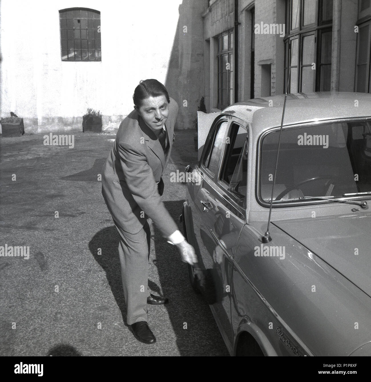 1951, vicino a Richmond Park, al di fuori di un mews house, un giovane ben-to-do gentleman è sempre nel suo Riley 'one-point-cinque " BMC autovettura, Richmond, Surrey, Inghilterra, Regno Unito. Con la sua buona gestione, compatto, sport-salone styling, una pinta-cinque è stato il veicolo perfetto per l'uomo in giro per la città. Foto Stock