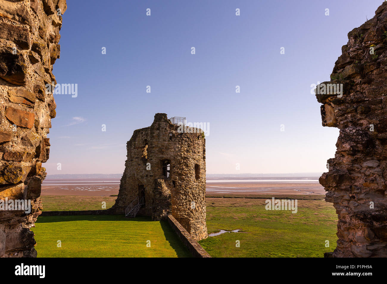 Rovine di Flint Castle si trova vicino al mare in Galles, Regno Unito sui primi mattina di primavera Foto Stock