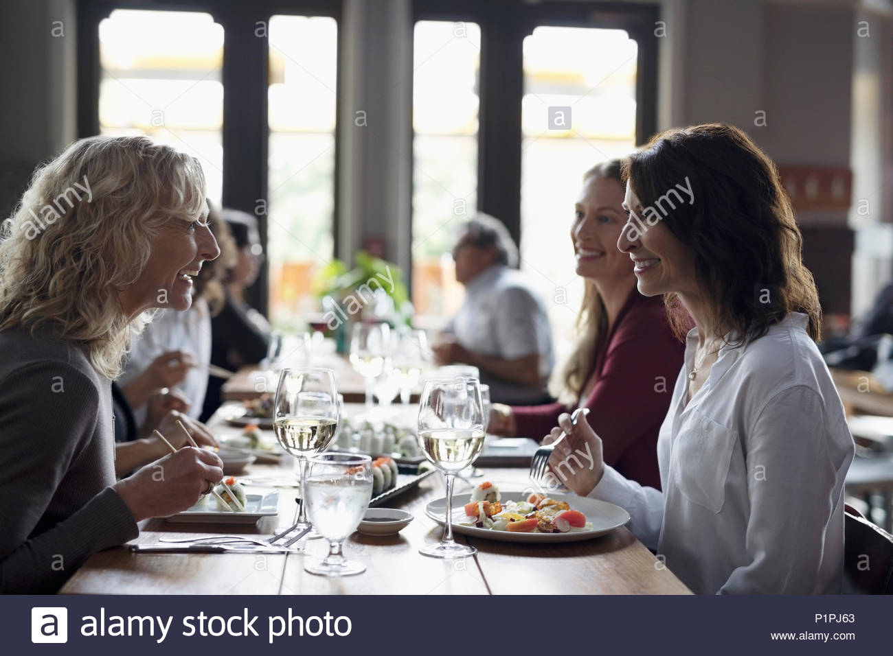 Le donne gli amici a mangiare il sushi, cenare al ristorante Foto Stock
