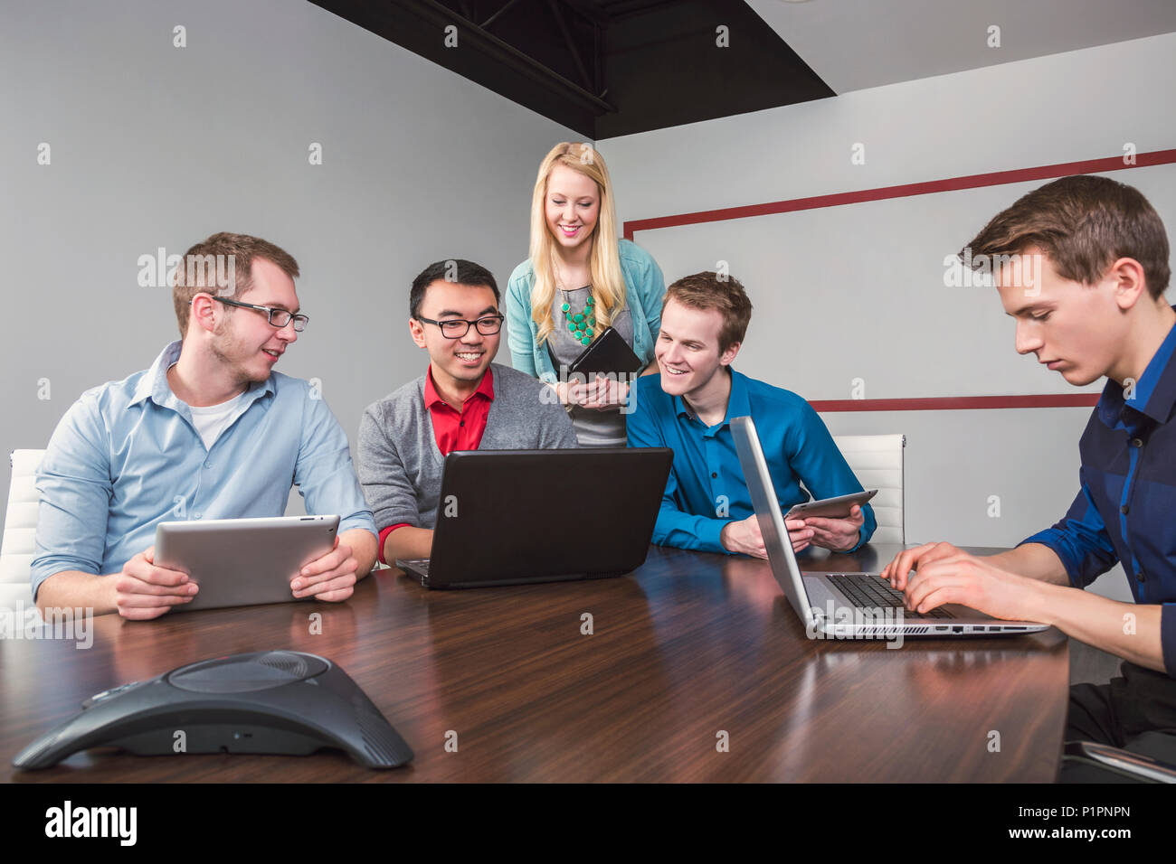 Millenaria di giovani professionisti che lavorano insieme in una sala conferenze in un high tech moderno business; Sherwood Park, Alberta, Canada Foto Stock