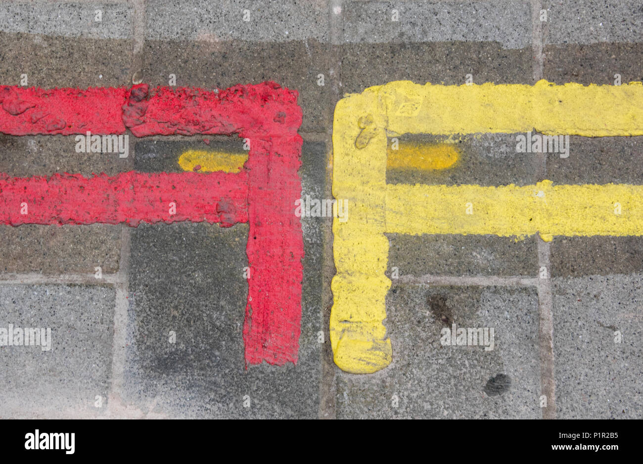 Doppie linee gialla e doppie linee rosse sul lato della strada che agiscono come le restrizioni per il parcheggio nel centro di Londra. linee dipinte a vietare il parcheggio. Foto Stock