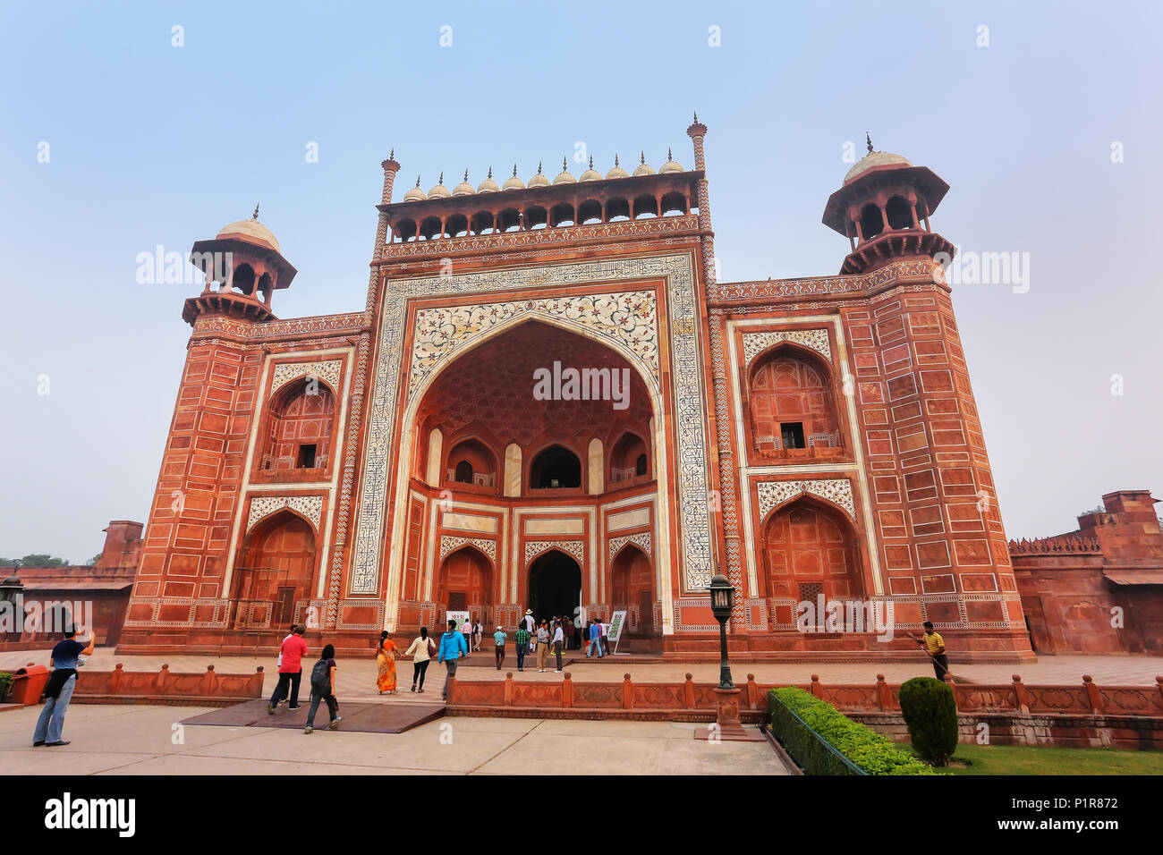 I turisti in piedi vicino Darwaza-i-Rauza (Porta grande) in Chowk-ho Jilo Khana cortile, Taj Mahal complessa, Agra, India. Il gate è l'entrata principale Foto Stock