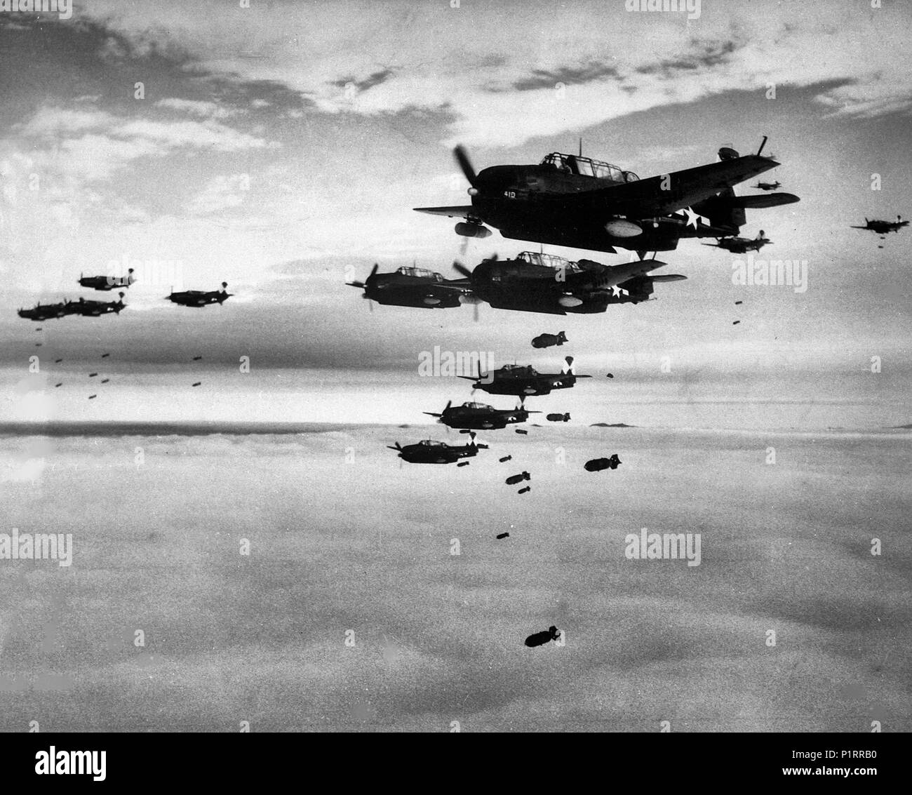 Stati Uniti Navy Grumman TBM-3 vendicatori e Curtiss SB2C Helldivers assegnati al vettore Air Group 83 (CVG-83) a bordo della portaerei USS Essex (CV-9) cadono le bombe su Hakodate, Giappone, nel luglio 1945. Foto Stock