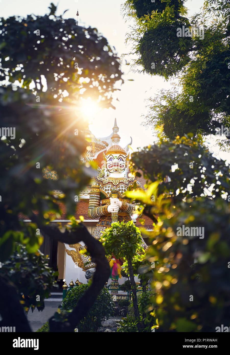 Il demone gigante statura vicino al tempio buddista di tempio Wat Arun a Bangkok al tramonto Foto Stock